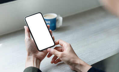 cell phone mockup image blank white screen.woman hand holding texting using mobile on desk at coffee shop.background empty space for advertise.work people contact marketing business,technology