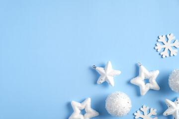 Fototapeta na wymiar Christmas minimal flat lay style composition with white stars, balls, snowflakes on blue background. Top view with copy space. Winter holidays, New Year, Christmas concept.