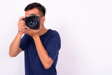 Portrait of young Asian man with camera