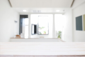 Empty wooden desk space and blurry background of home window for product display montage.