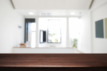 Empty wooden desk space and blurry background of home window for product display montage.
