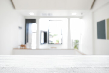 Empty wooden desk space and blurry background of home window for product display montage.