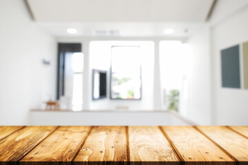 Empty wooden desk space and blurry background of home window for product display montage.