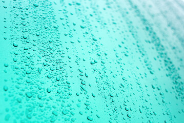 Water drops of rain on blue background. Summer rain drops. Closeup view.