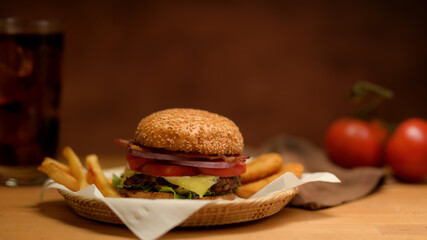 Fresh tasty grilled burger and french fries serving on wicker tray