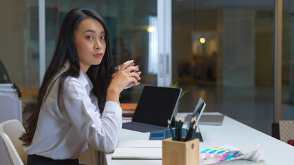 Portrait of female entrepreneur take a break with hot beverage in glass partition office room