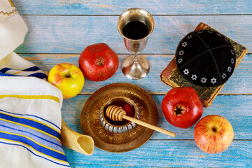 Shofar and tallit with glass honey jar and fresh ripe apples. Jewesh new year symbols. Rosh hashanah