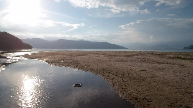 Dinamic drone shot of a small river entering the Lake Maggiore (Lago Maggiore). This lake is situated in italy in Lombardia, it connects also to Switzerland. shot filmed in Ispra (Italia).