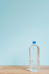 Big plastic bottle of water on the table.  テーブルの上の大きなプラスチックボトルの水