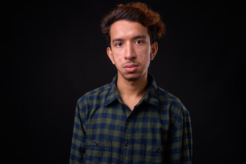 Portrait of young Asian hipster man with curly hair