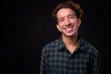 Portrait of happy young Asian hipster man with curly hair