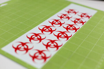 Red biohazard vinyl stickers on green matt made using a cutting machine