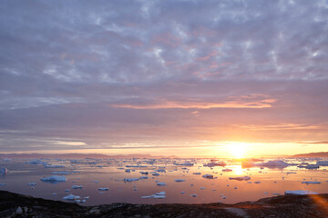 Midnight Sun and icebergs in Disko Bay, Ilulissat, West Greenland