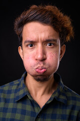Portrait of young Asian hipster man with curly hair