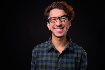 Portrait of happy young Asian hipster man with curly hair
