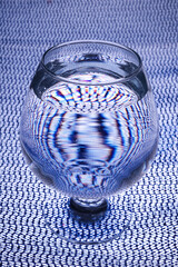 lying cognac glass with vodka or pure alcohol on a checkered surface. night life. evening scene....