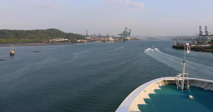 Panama Canal cruise ship bow in Gatun Lake. System lifts a ship 85 feet between the Atlantic and Pacific Ocean. Nation 52 miles long. Tug boats, electric train engines pull the cargo. Thousands ships.