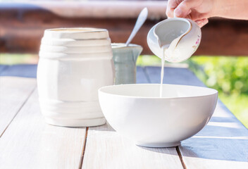 Milk pouring from a milk jug into a bowl