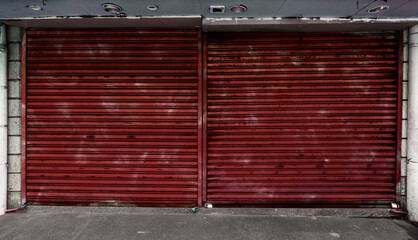 Weathered Red oxide colored corrugated metallic Roll up doors. Concept of closed, shuttered or...