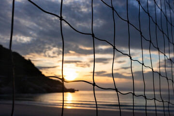 A volleyball net on sunset sky background at the beach. Koh Pangan island, Thailand. Closeup.