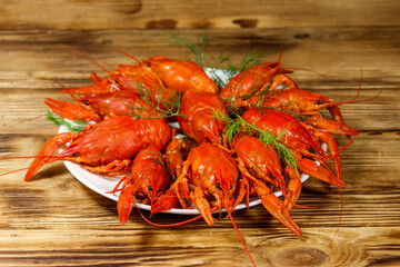 Boiled crayfish in plate on wooden table