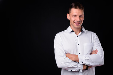 Fototapeta premium Portrait of happy businessman against black background
