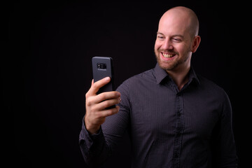 Portrait of happy handsome bald bearded businessman