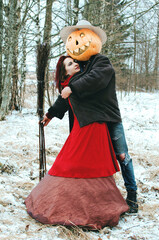 Halloween Scarecrow with a pumpkin on his head and a witch love each other