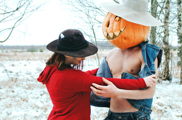 Halloween Scarecrow with a pumpkin on his head and a witch love each other