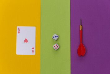 Ace of hearts, darts and dice on colored background. Top view