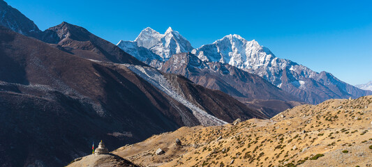 Kangtega and Thamserku mountain peak view from Dingboche village in Everest base camp trekking route. Himalaya mountains range in Nepal. Panoramic banner portion.