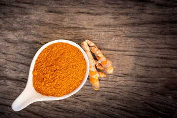 Turmeric ( Tumeric, curcumin, Curcuma longa Linn ) powder and rhizome isolated on wood.
