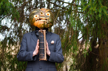 Halloween Scarecrow in a business suit with an old book in his hands