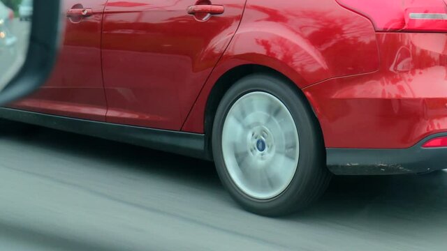 Close-up on wheel of red moving car