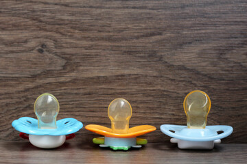 Three orthodontic pacifier on a wooden background