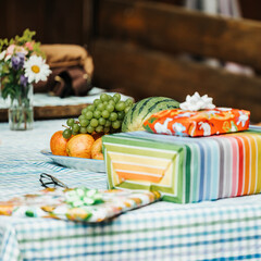 Birthday gifts lying on a table with a fruit plate with grapes, watermelon and apples