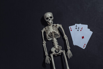 Skeleton and four aces on black background. Gambling addiction. Top view