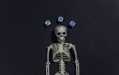 Skeleton and dice on black background. Gambling addiction. Top view