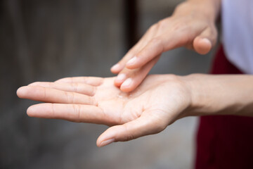 woman washing her hand with alcohol gel or hand sanitizer; new normal lifestyle with COVID-19...