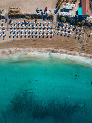 Aerial view over Coral Bay - the most beautiful beach in Paphos area, Cyprus. Crystal clean blue and turquoise  waters and soft white sand makes it a perfect summer vacation destination.