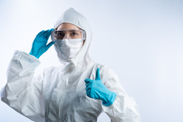 Female doctor in PPE (personal protective equipment), wearing gloves face mask and take off safety glasses.
