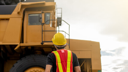 Worker in lignite or coal mining with the truck transporting coal.