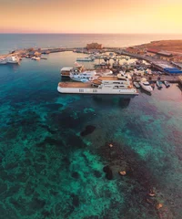 Gordijnen Beautiful aerial sunset shot of Paphos Castle and Paphos Harbor in Cyprus. Crystal clear water, fishing boats, luxury yachts - amazing travel destination for all year vacation.  © Evgeni