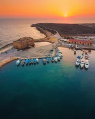 Poster Beautiful aerial sunset shot of Paphos Castle and Paphos Harbor in Cyprus. Crystal clear water, fishing boats, luxury yachts - amazing travel destination for all year vacation.  © Evgeni
