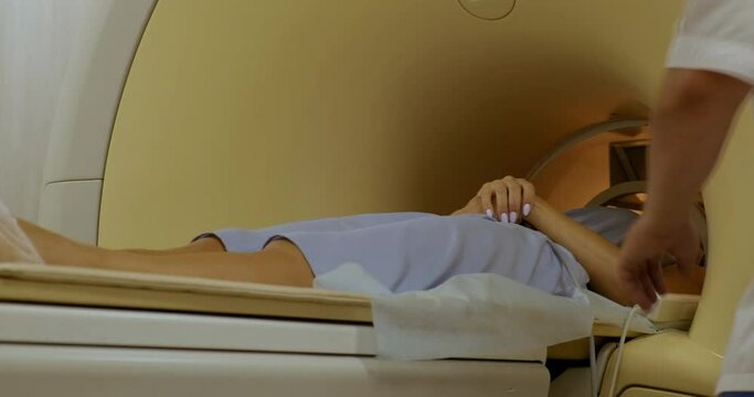 Movable Part of MRI Machine Slides out of Magnetic Field Zone. Completion of Diagnostics. Girl Lies on Platform with her Hands Crossed. Long Medical Research Procedure. Hospital. Disease. Health Check