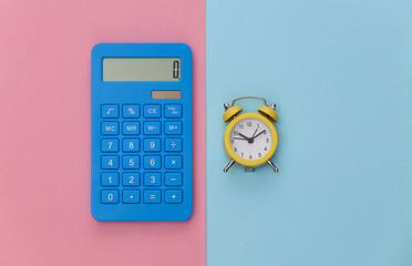 Calculator and alarm clock on pink blue pastel background. Top view. Flat lay