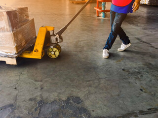 Worker driving forklift loading and unloading shipment carton boxes and goods on wooden pallet from container truck to warehouse cargo storage in logistics and transportation industrial 