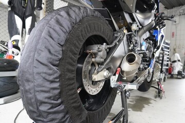 タイヤウォーマーを装着したレーシングバイクのタイヤ/Racing machine with equipped tire warmer