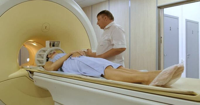 Doctor at Medical Center Begins Examining Patient's Body Using Magnetic Resonance Imaging Machine. Woman in Blue Dress Lies Calmly on Moving Platform of Apparatus. Finding Malignant Tumor. Research
