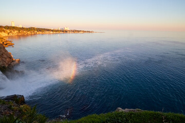 Waterfall with water falling in sea in the evening time. Waterfall Duden at Antalya in Turkey. Concept of nature travel
